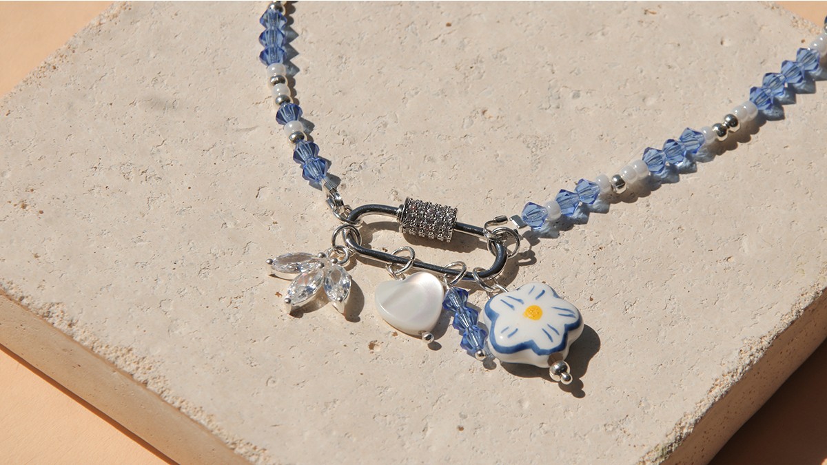 Collier fermoir ovale, toupies bleues et accumulation de breloques Collier fermoir ovale, toupies bleues et accumulation de breloques