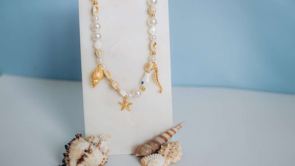 Collier en perles céramiques, perles nacrées et breloques marines Collier en perles céramiques, perles nacrées et breloques marines